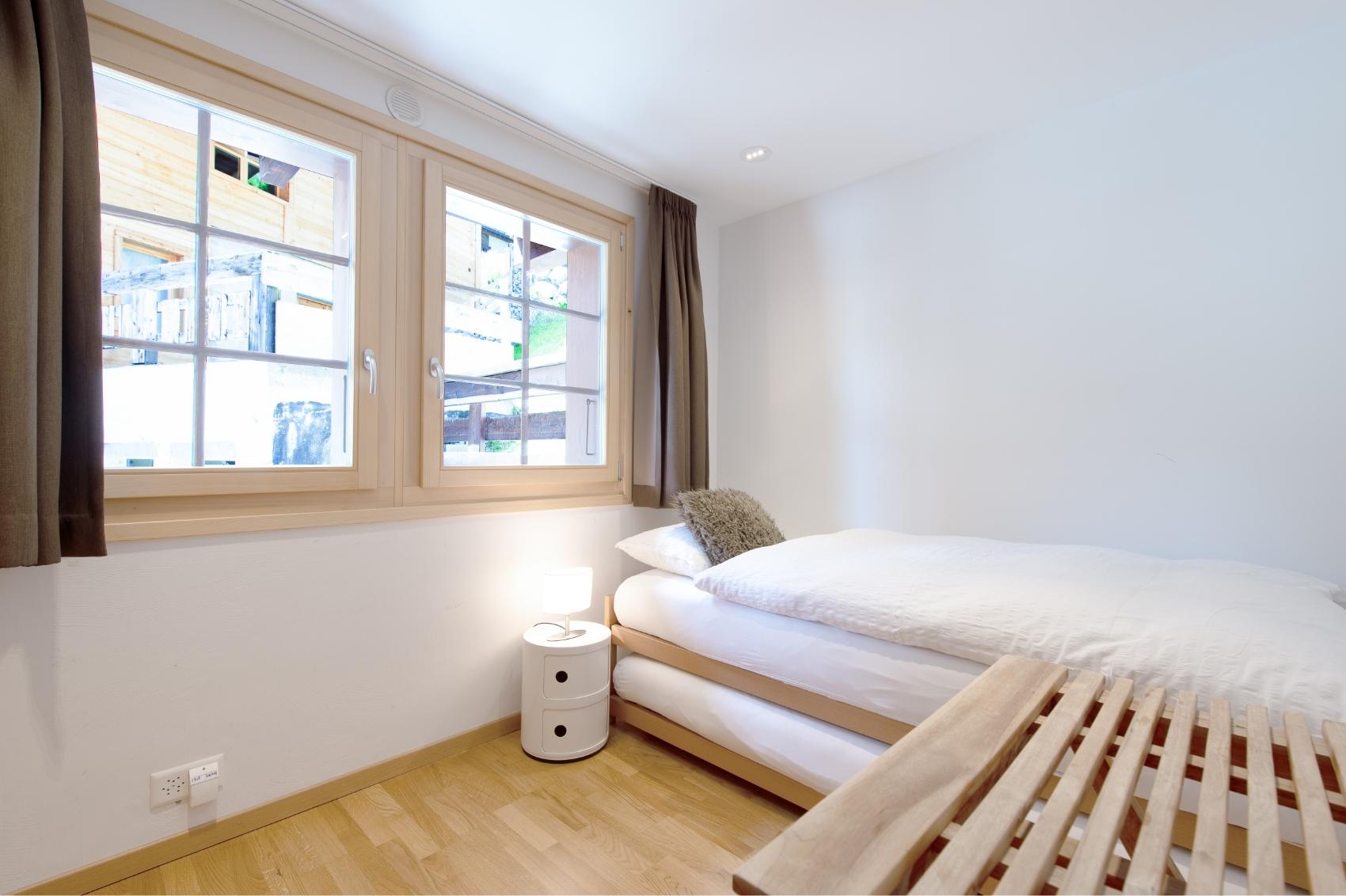 Private single room with a single bed, bedside table, and window with mountain views