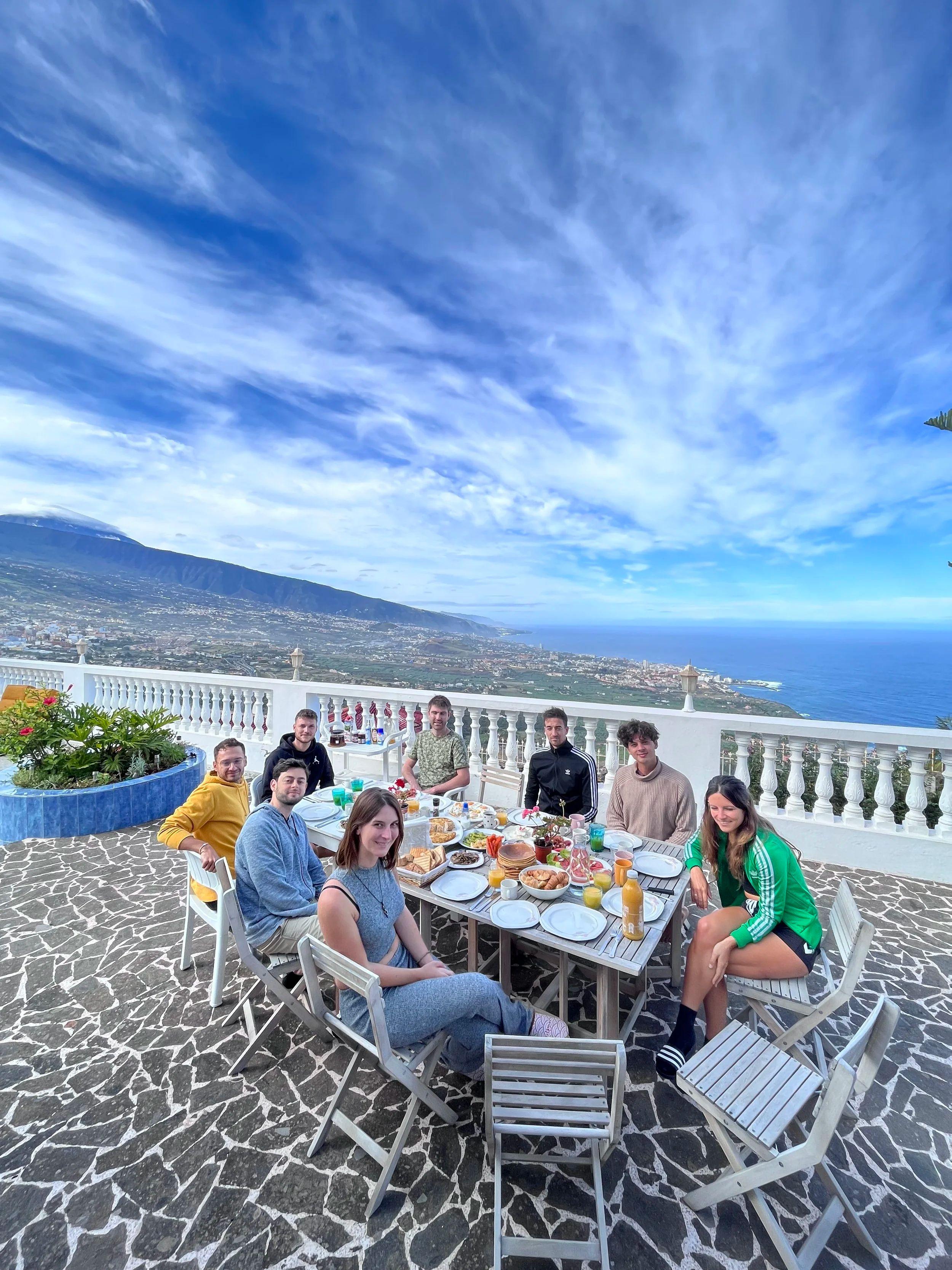 Community members sharing a meal at a table on the upper deck terrace with panoramic views