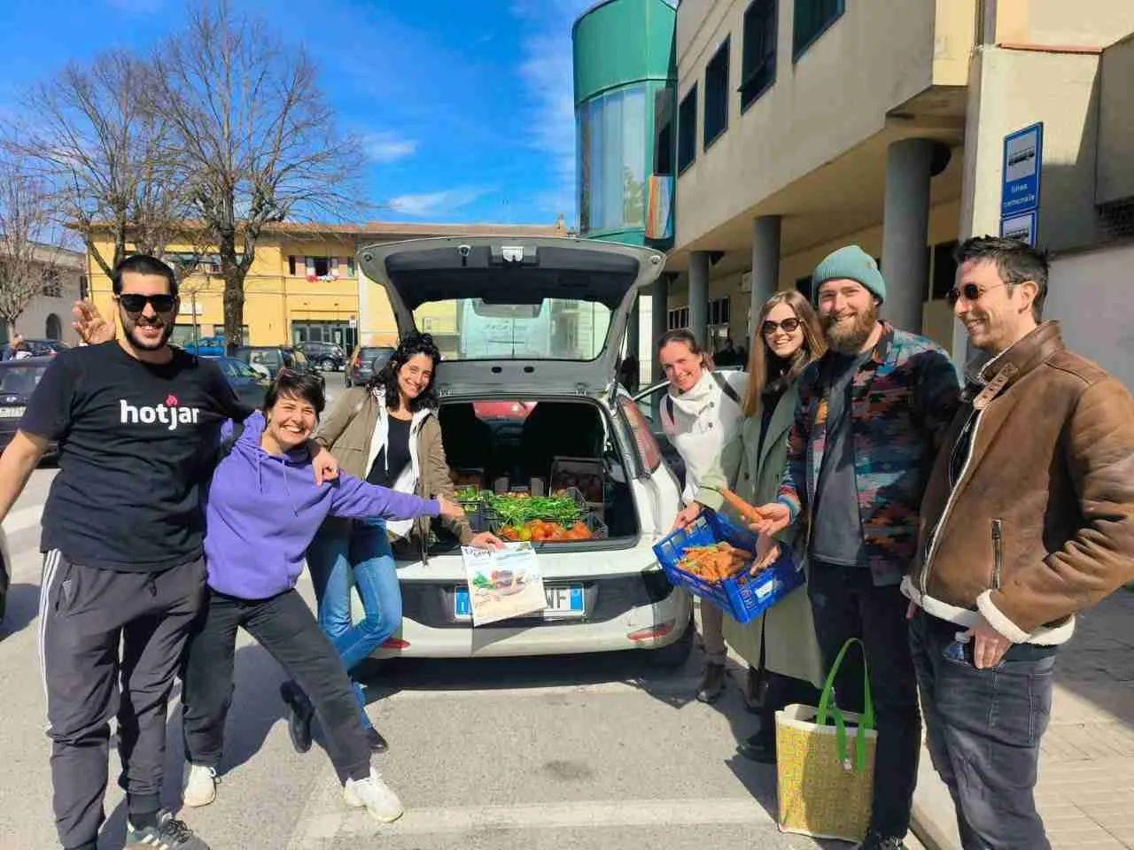 Group of colivers at a local market or food harvest outing, loading fresh produce into a car
