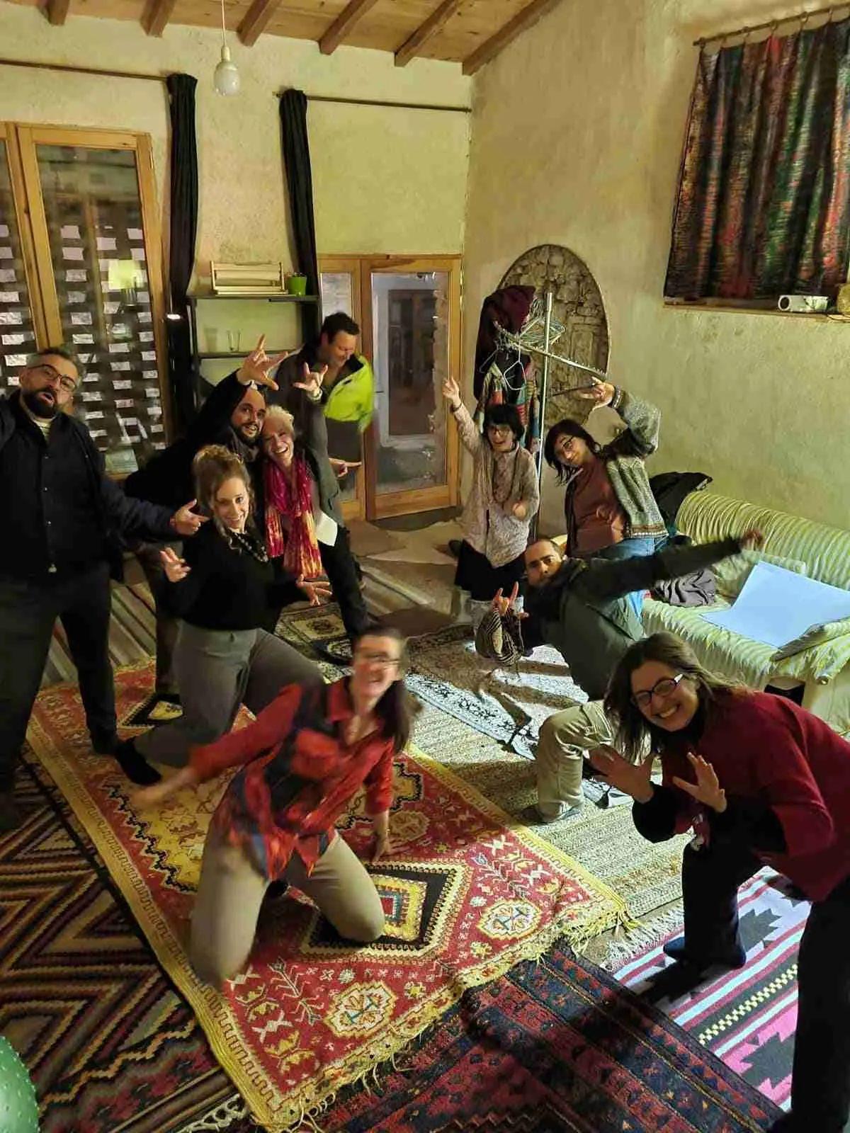 Group of colivers celebrating New Year's Eve in the barn, posing playfully on colorful rugs