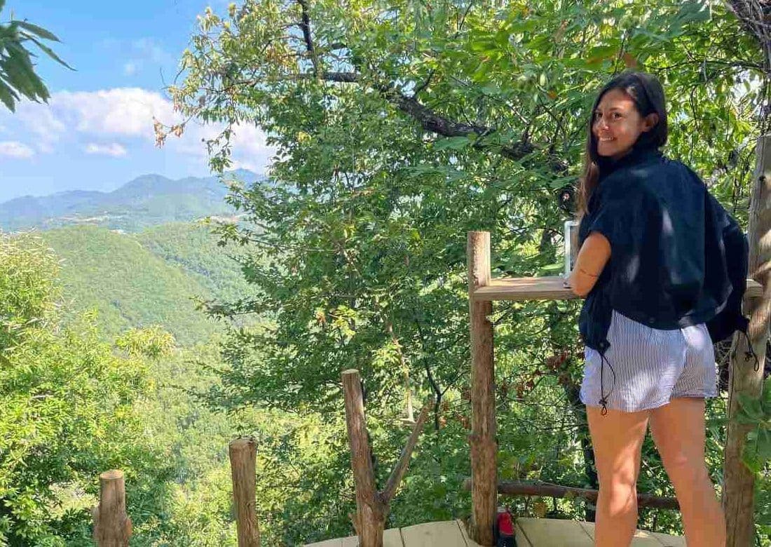 A coliver working at a standing desk on the forest terrace overlooking the Mugello valley and forest