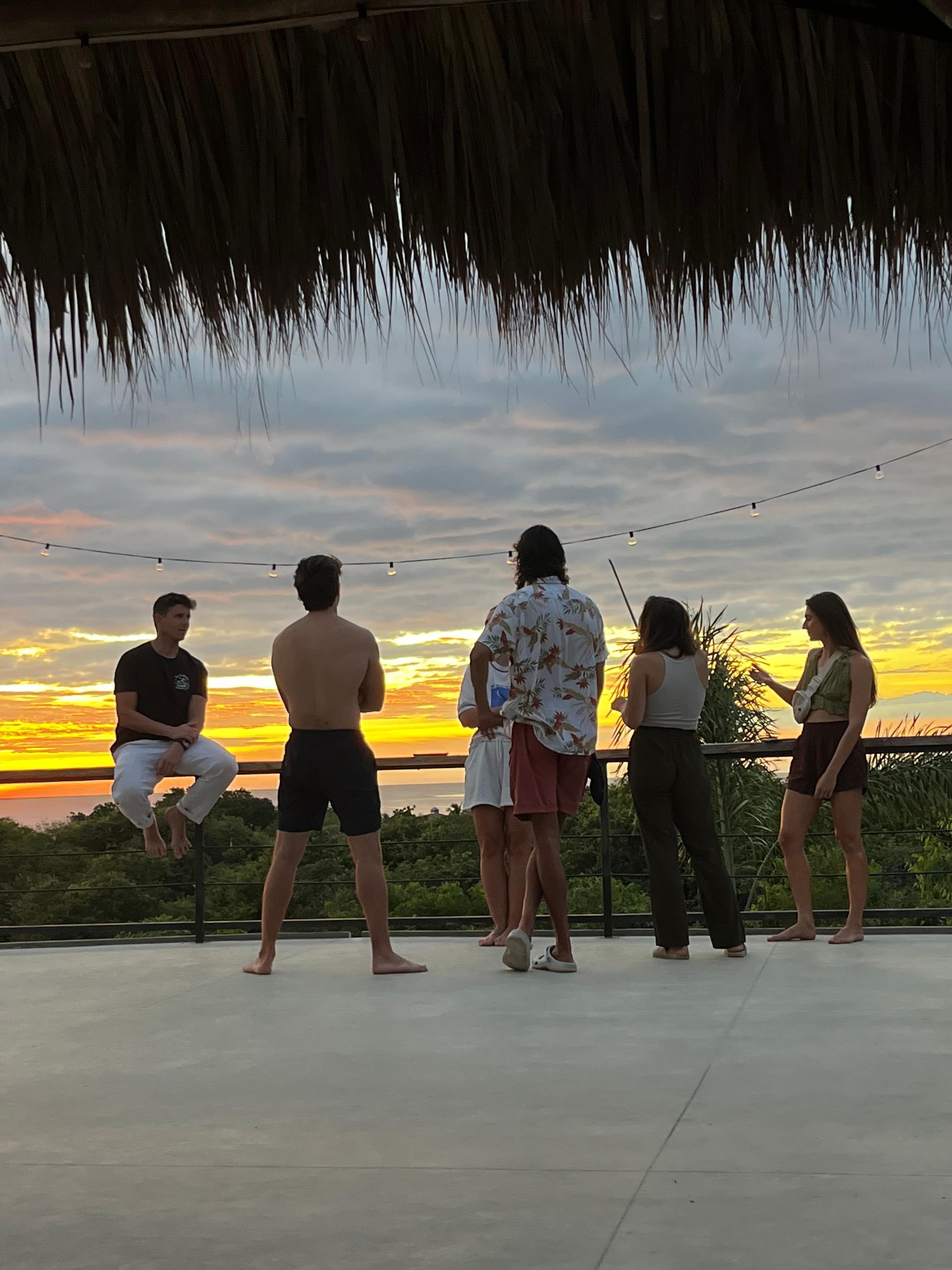 Guests watching the sunset from the rooftop palapa