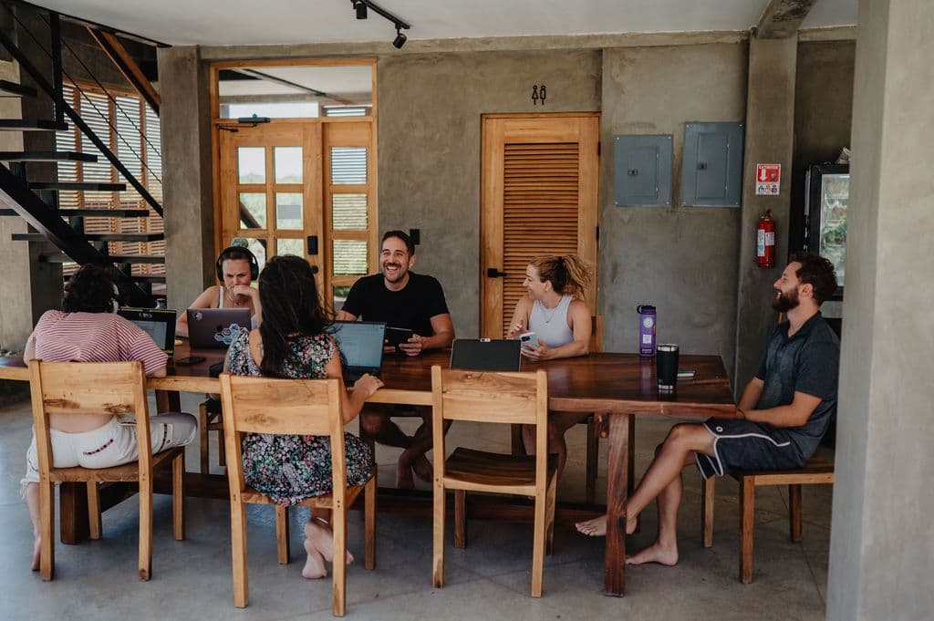 Group of guests working together at the communal table in the coworking space