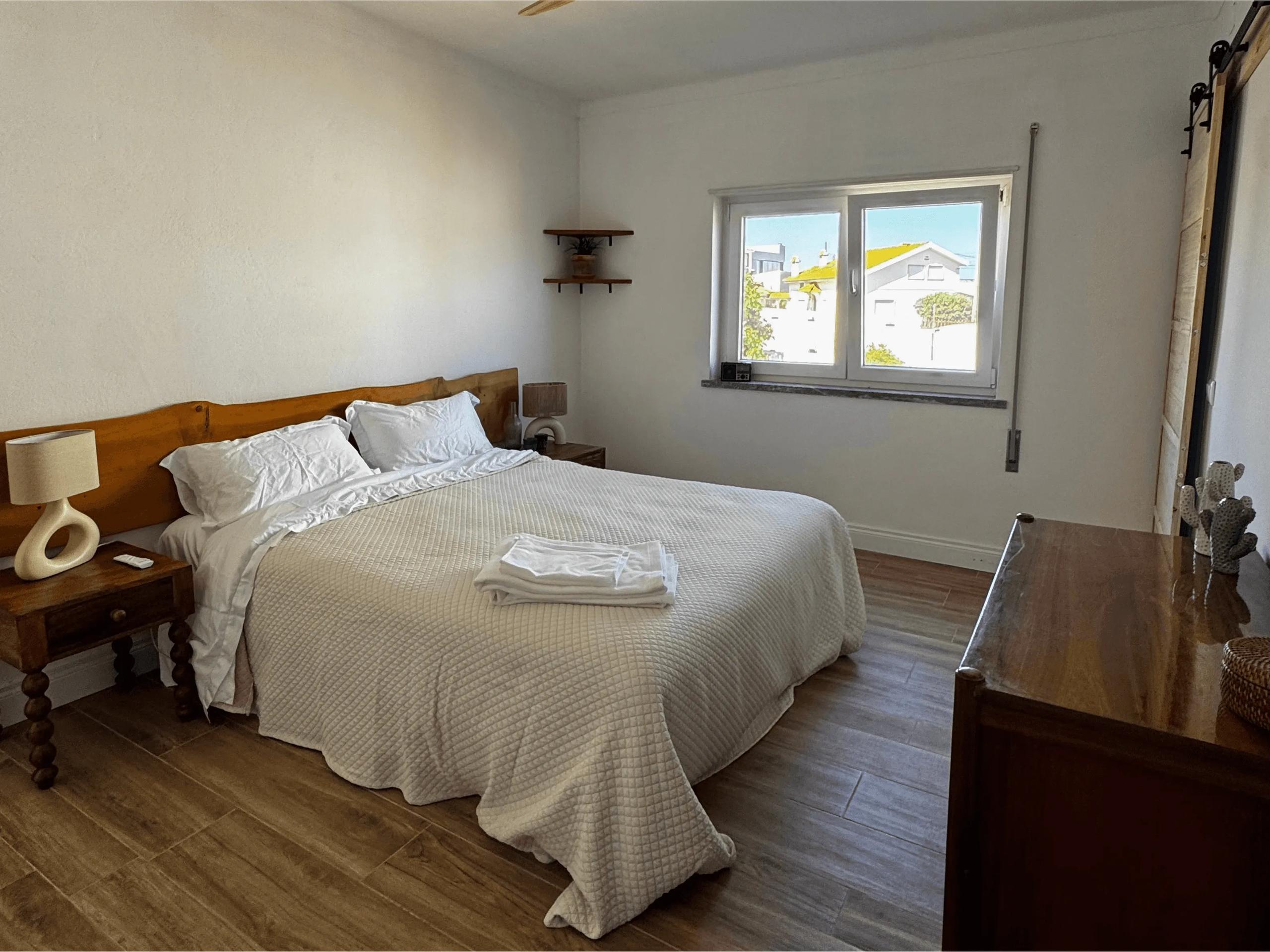 Double bedroom with wooden headboard, ceiling fan, and blue doors