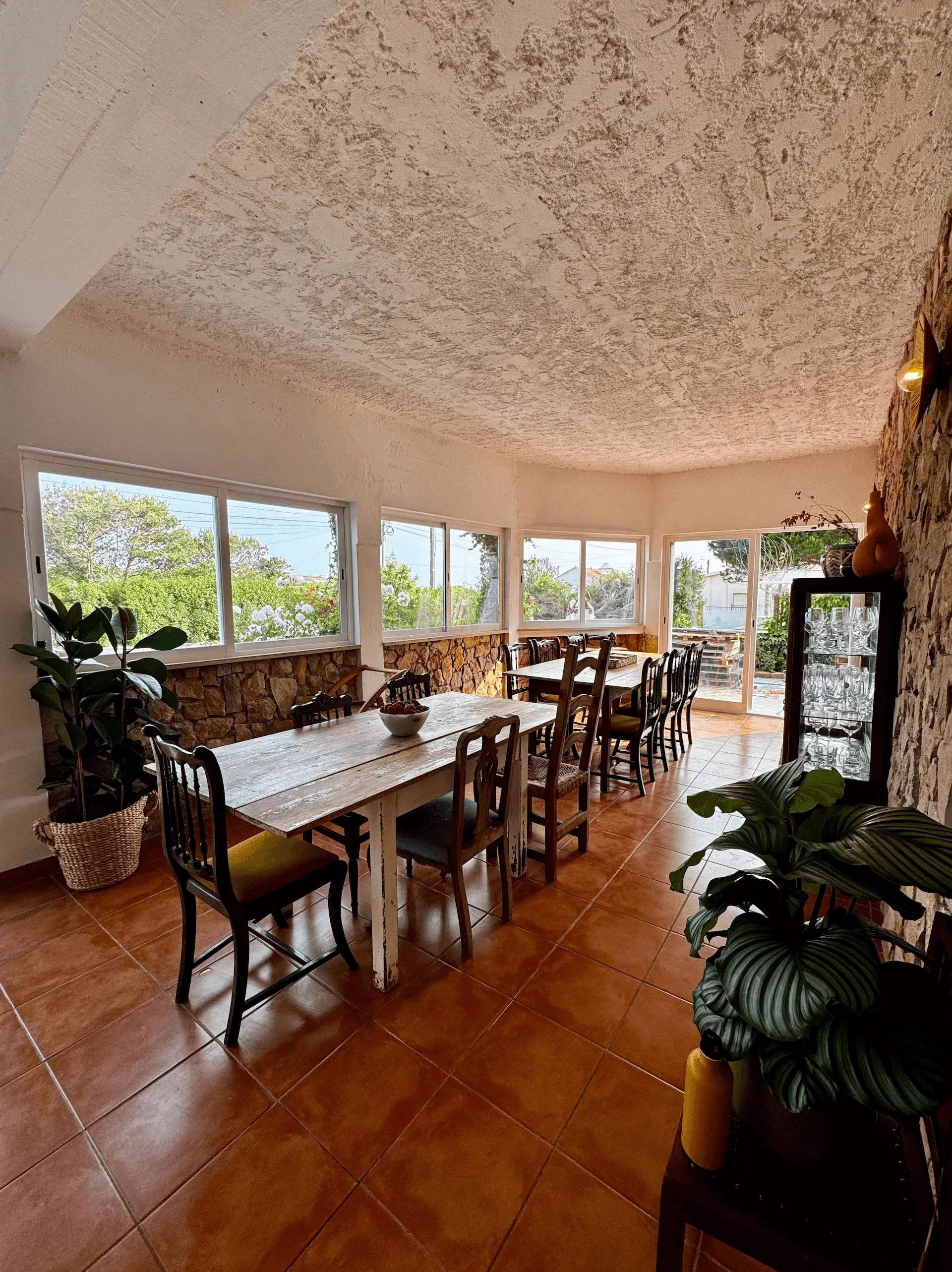 The dining and living room at Wild Souls with long tables, chairs, and garden views